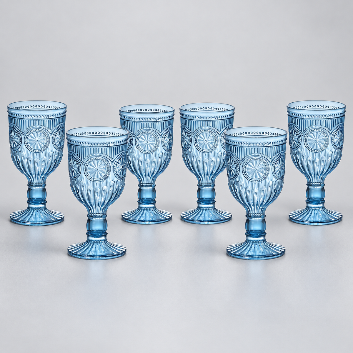Set of six smoky blue embossed plastic goblets on a neutral studio background