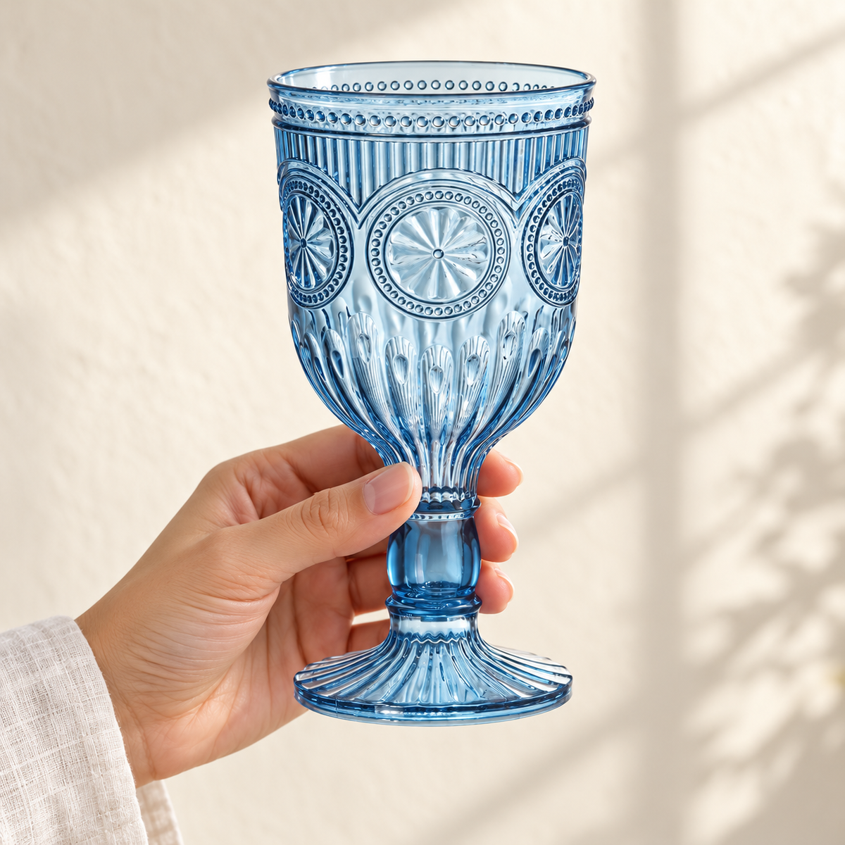 Smoky blue embossed plastic goblet held by an adult hand