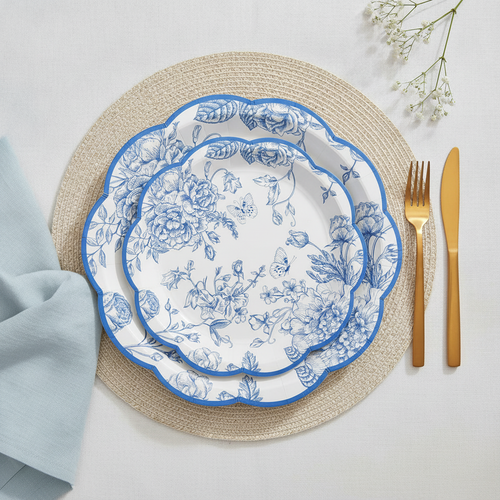 Overhead flat-lay of blue floral disposable paper party plates with gold cutlery