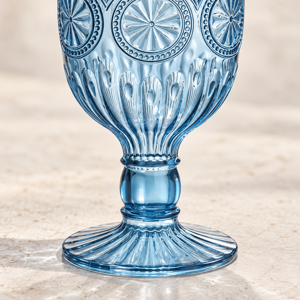 Close-up of sunflower embossing, short stem and fluted foot on a smoky blue plastic goblet