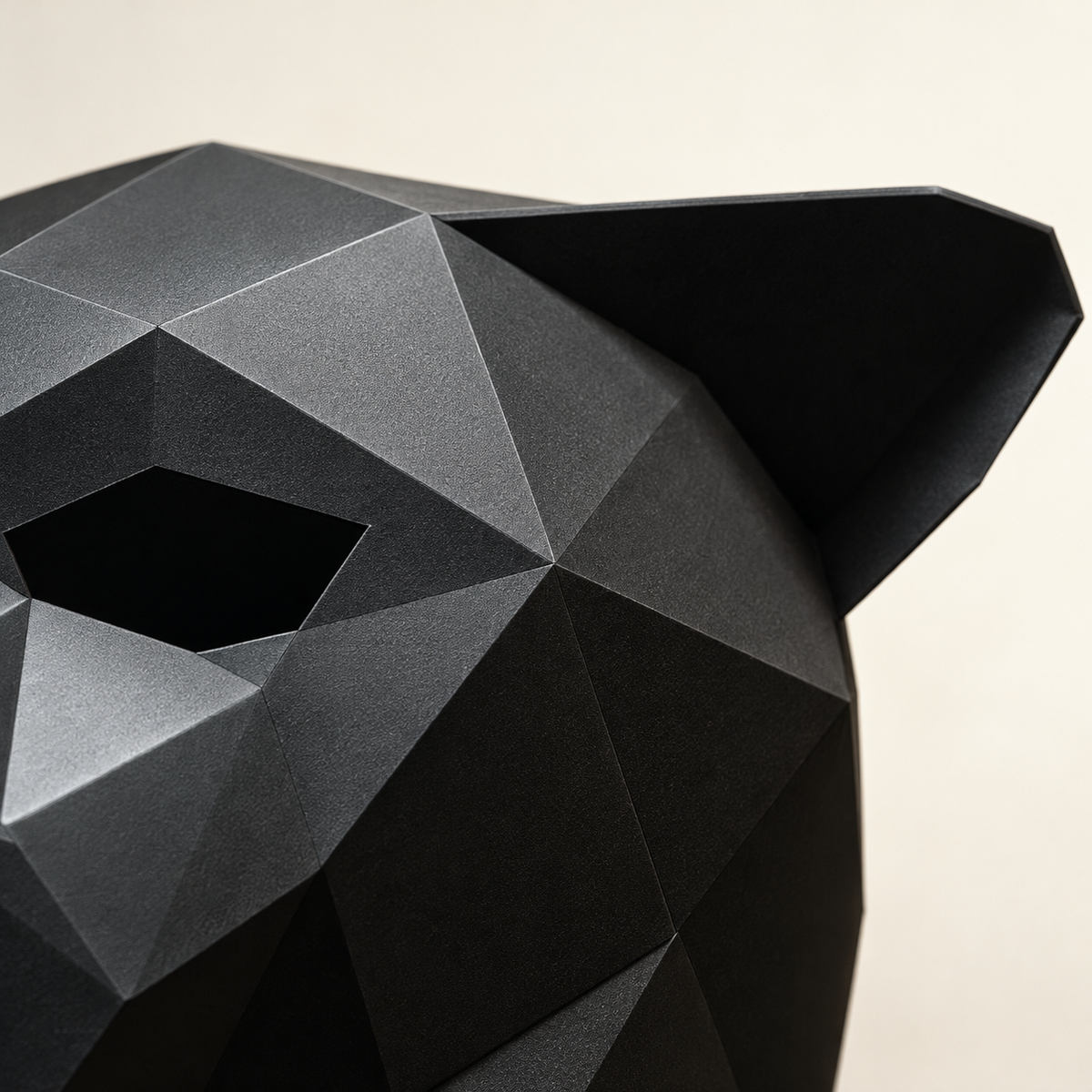 Close view of the black animal mask's pointed ear and angular forehead planes.