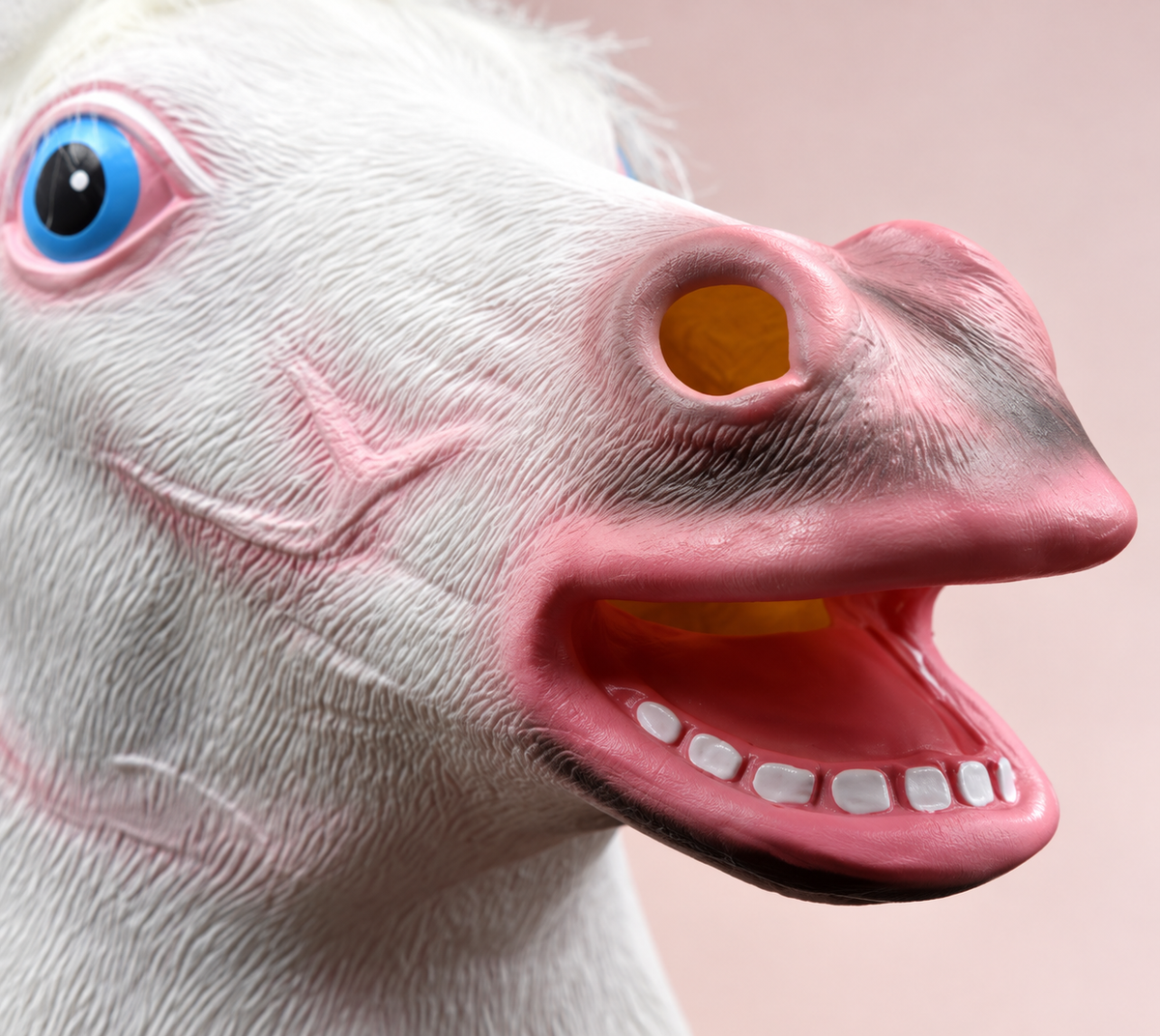 Close view of the unicorn mask's pink muzzle, visible nostril opening and fixed lower teeth.