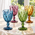Four diamond-textured stemmed goblets in amber, green, blue and pink-purple; styling surfaces not included.