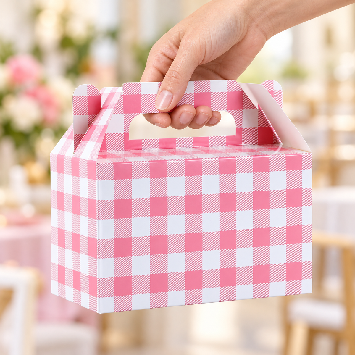 Pink gingham favor box, hand view. Representative portion of the 12-pack; styling props are not included.