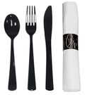Black spoon, fork and knife beside a rolled white napkin with a black printed band. One representative place setting from the 50-unit pack.