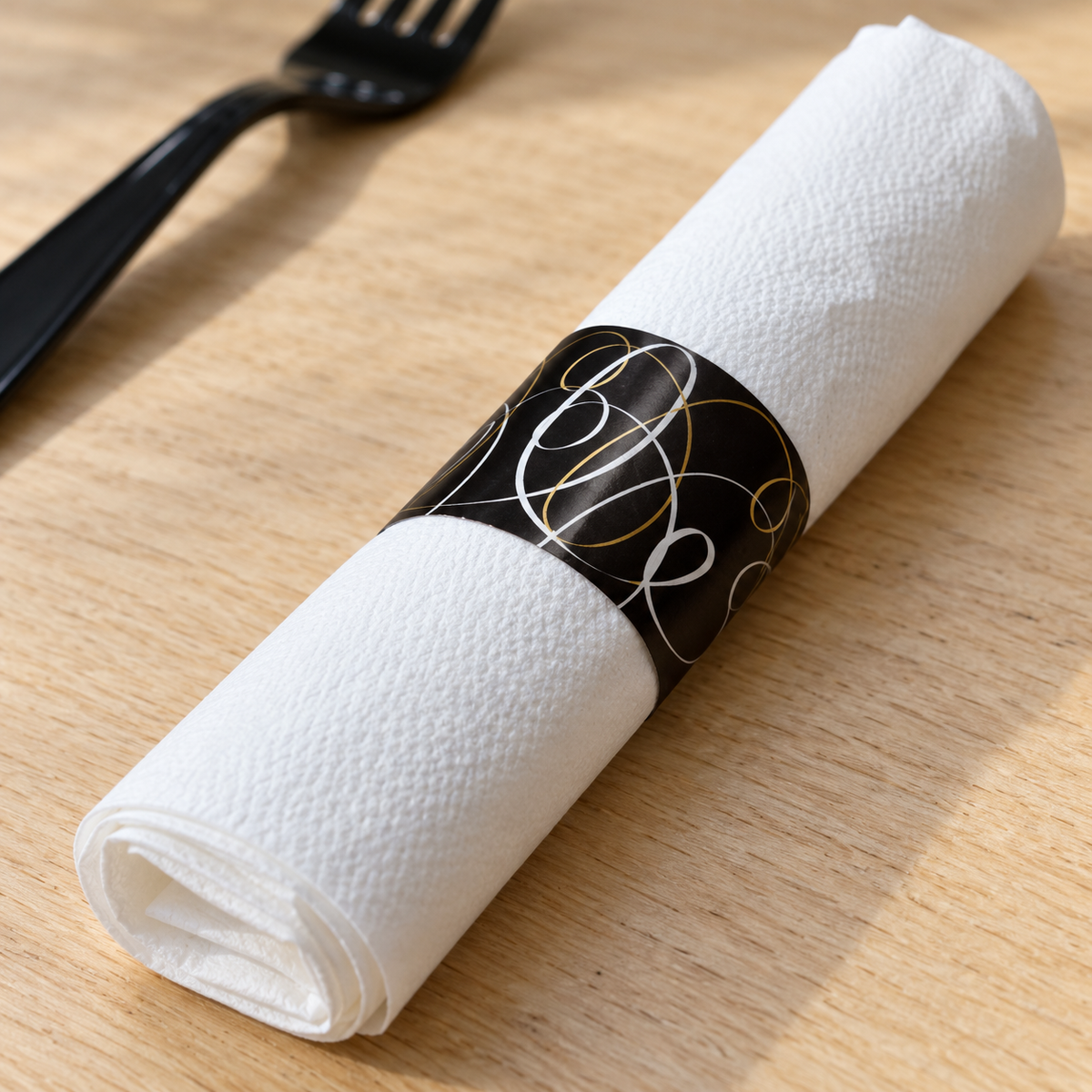 Close-up of a white paper napkin roll and its black printed band.