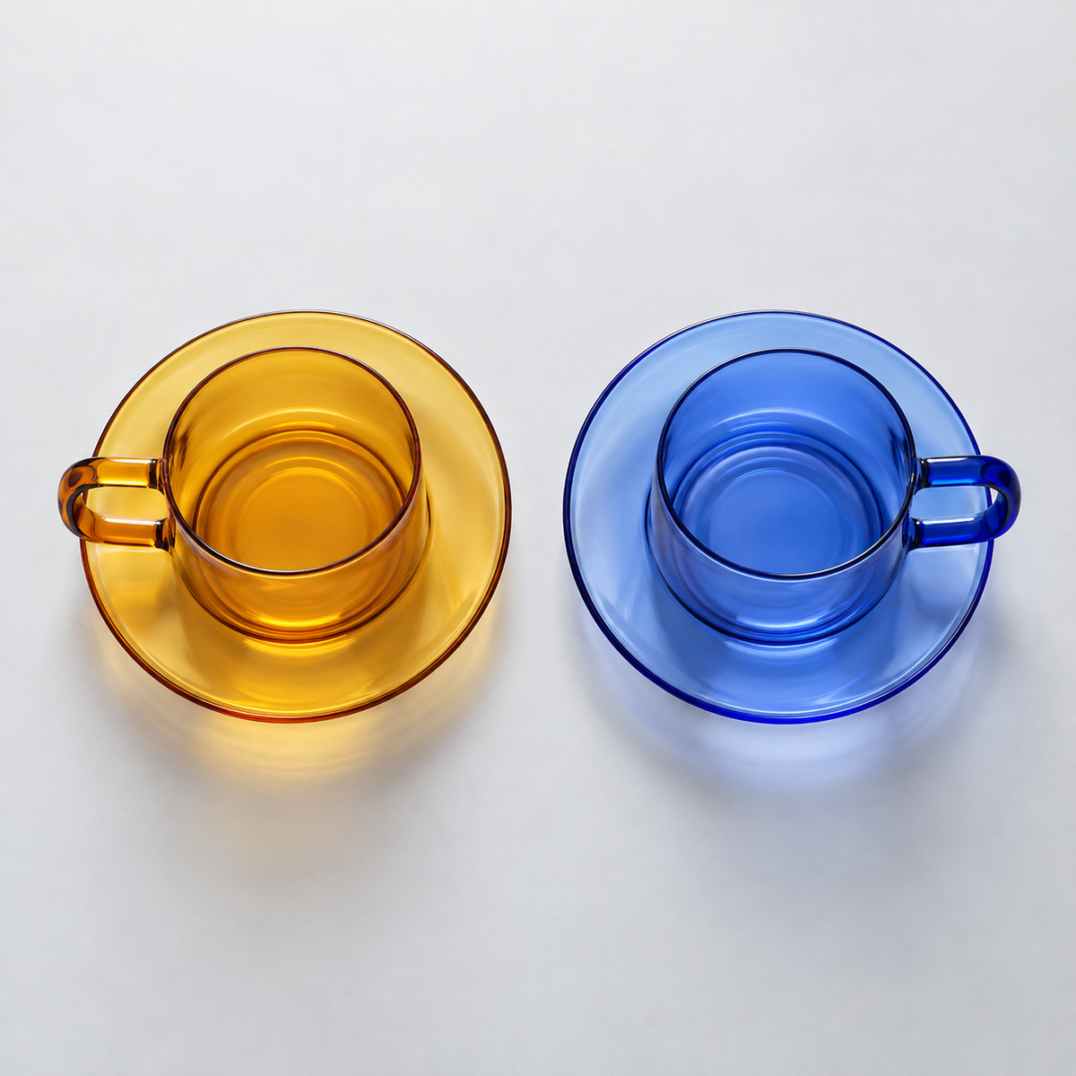 Overhead view of the Blue and Yellow glass cup-and-saucer options; each color is sold separately.