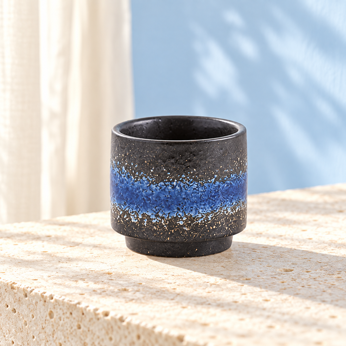 Blue glazed ceramic tea cup on a bright surface; other color variants are not pictured. Styling props are not included.