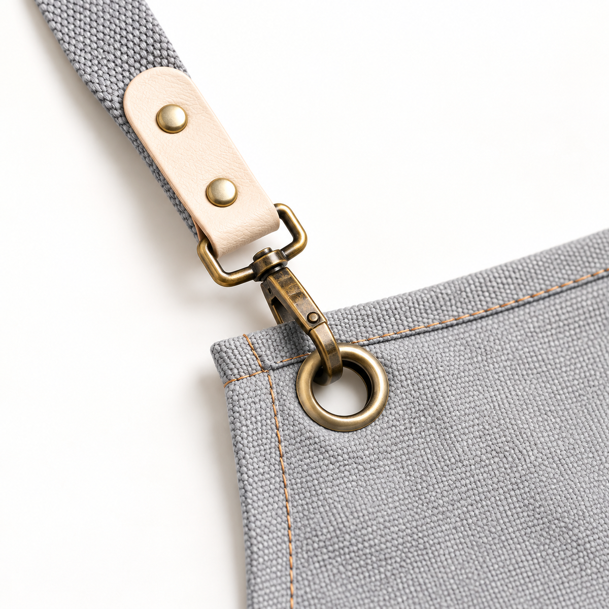 Detail of the apron strap tab, clasp, eyelet and canvas stitching.