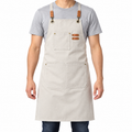 Beige canvas cross-back apron worn from the front on a white studio background.