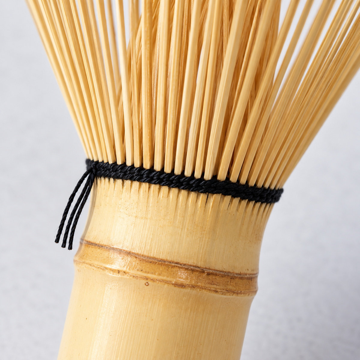 Close exterior detail of bamboo grain, the bamboo node and black thread binding on the matcha whisk.
