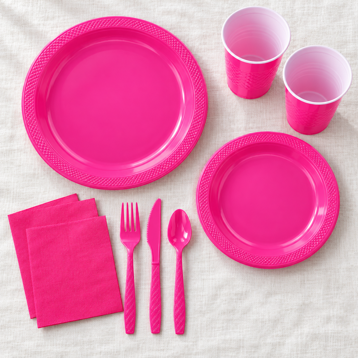 Overhead arrangement of hot pink party tableware; representative selection from the 168-piece set.