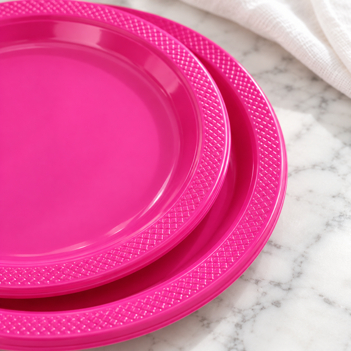 Close view of the molded patterned rims of hot pink plates.