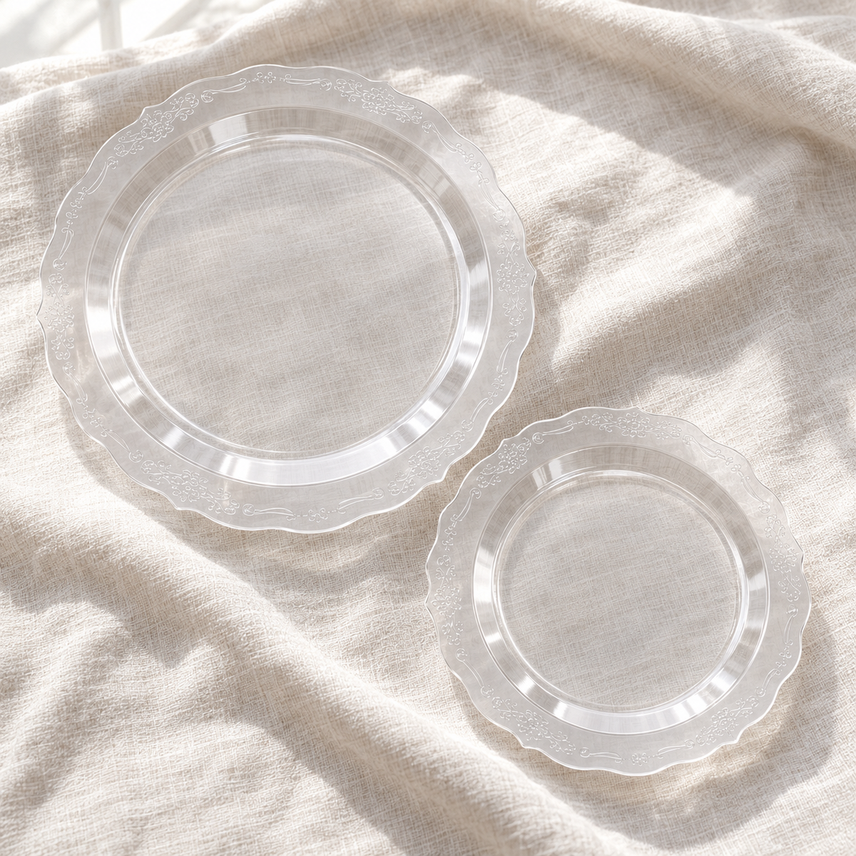 Two clear Victorian-style plates face up on linen; representative selection from the set.
