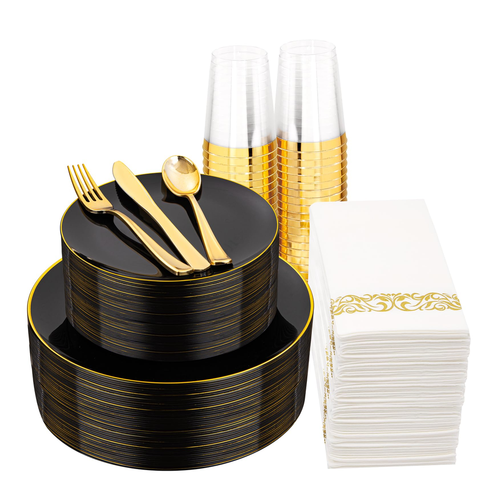 Black plates with fine gold rims, clear gold-rim cups, gold-colored plastic cutlery and white napkins with the original gold scroll band on a white background.
