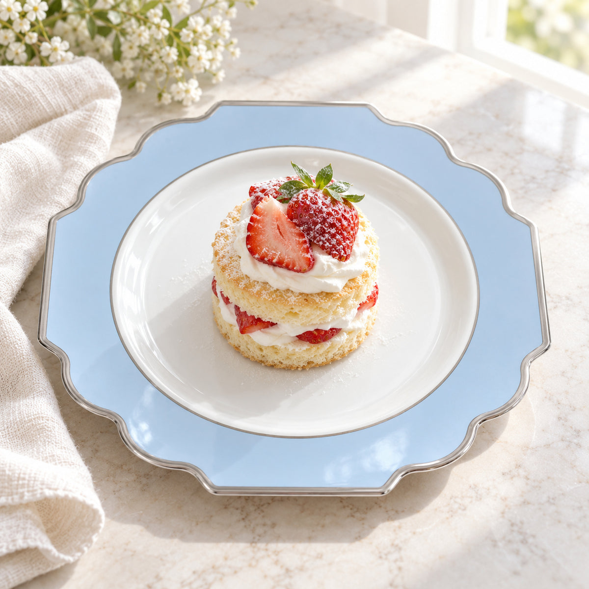 White, pale-blue and silver ornamental appetizer plate styled with an individual strawberry dessert. Food and linens are styling props. Food and styling props not included.