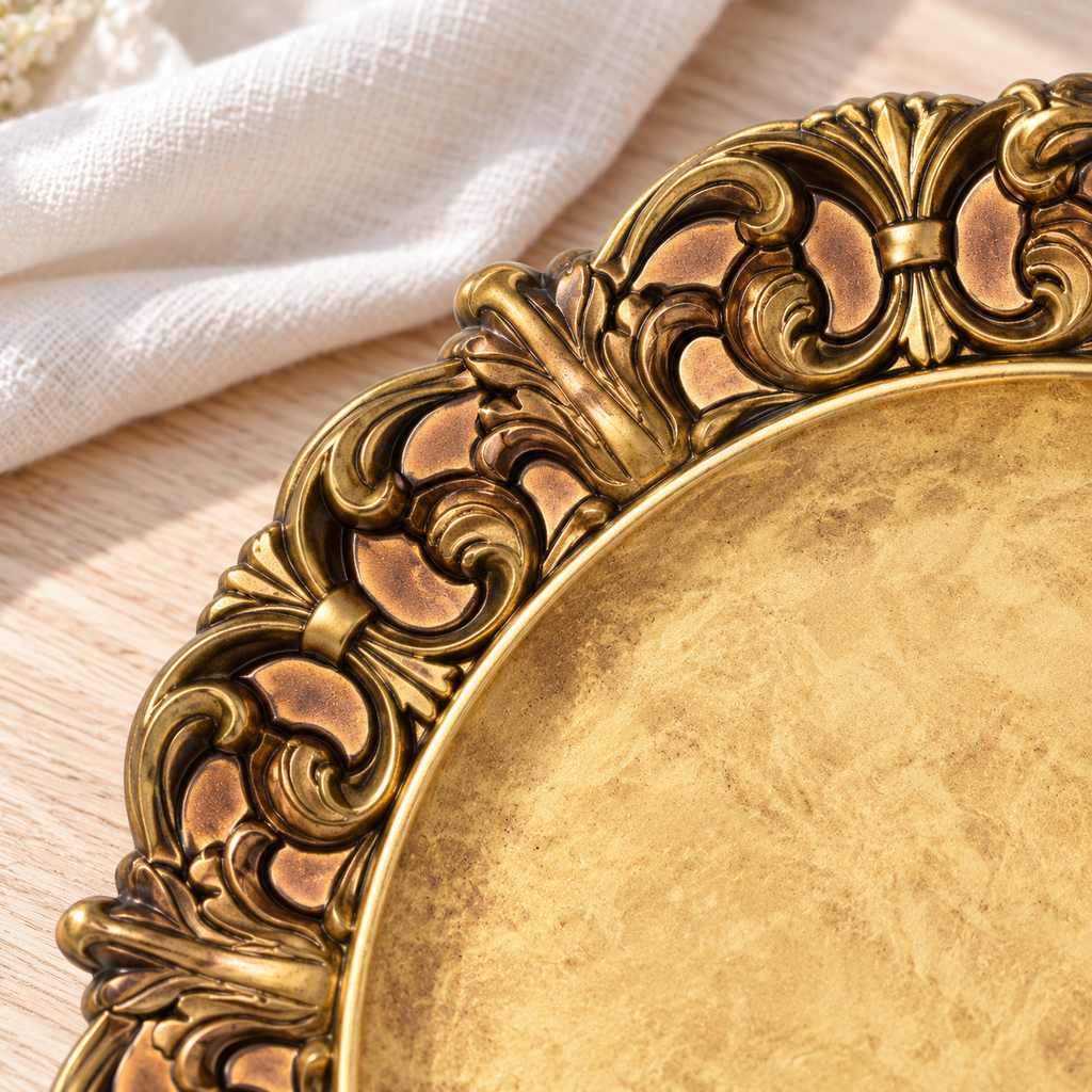 Close-up of the antique gold charger’s raised scroll and leaf border with dark antiqued grooves and solid copper-gold recesses.