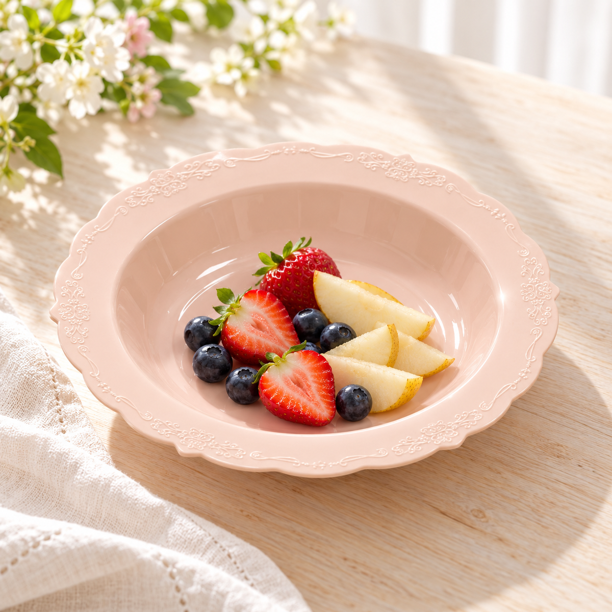 Blush pink soup bowl holding a small fruit serving on a bright table. Food and styling props not included.