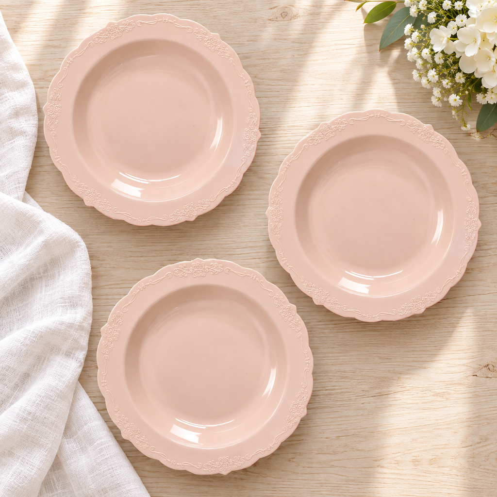 Overhead view of blush pink soup bowls with scalloped embossed rims. Food and styling props not included.