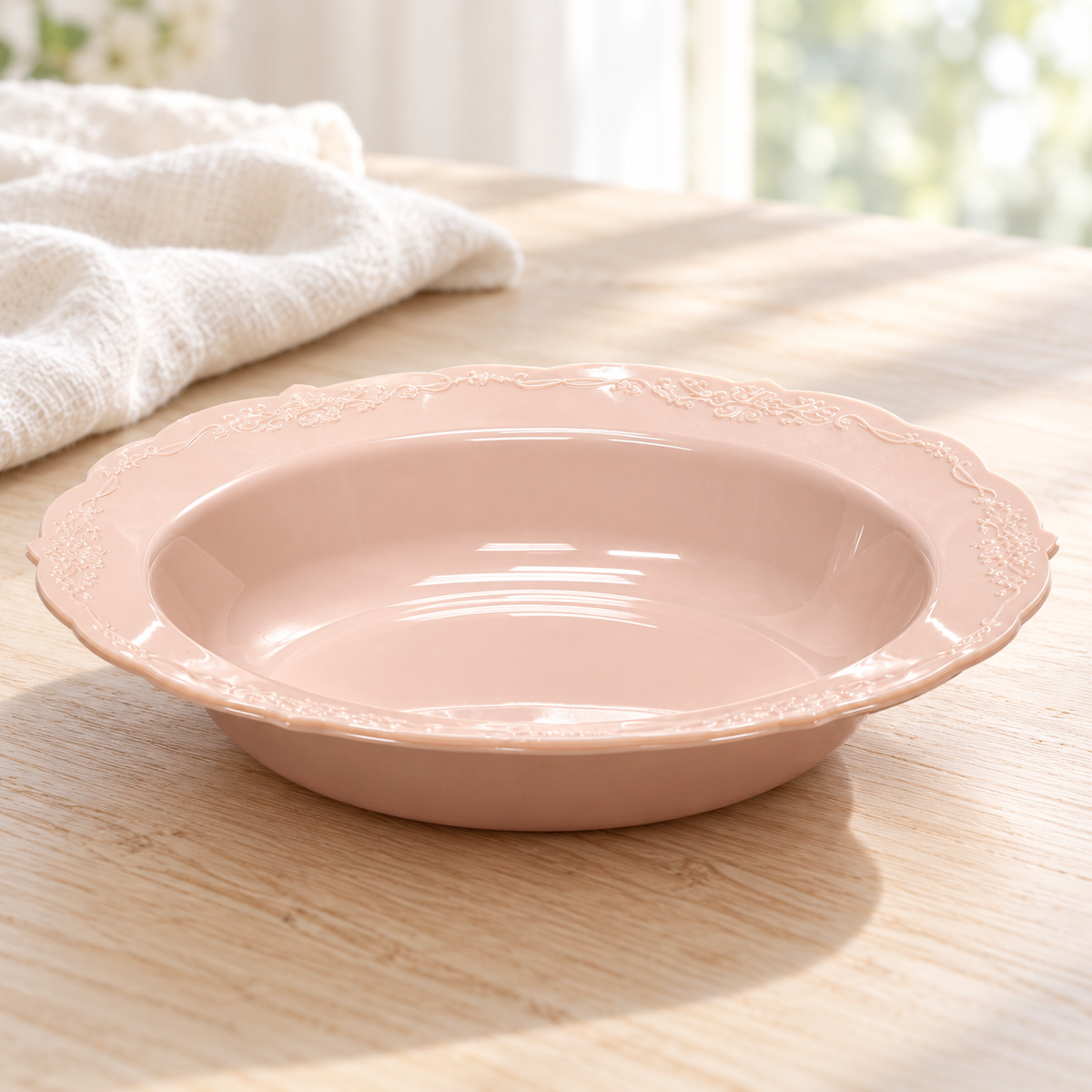 Low angled view showing the shallow depth and thin rim of a blush plastic soup bowl.