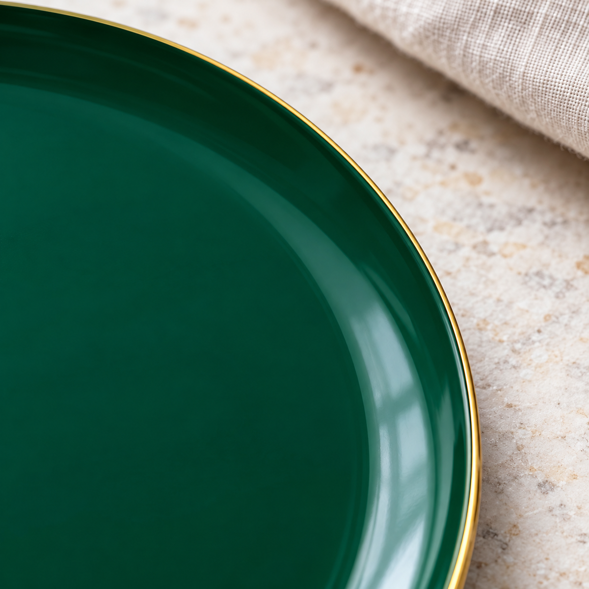 Close-up of a green plate’s thin gold rim and shallow well.