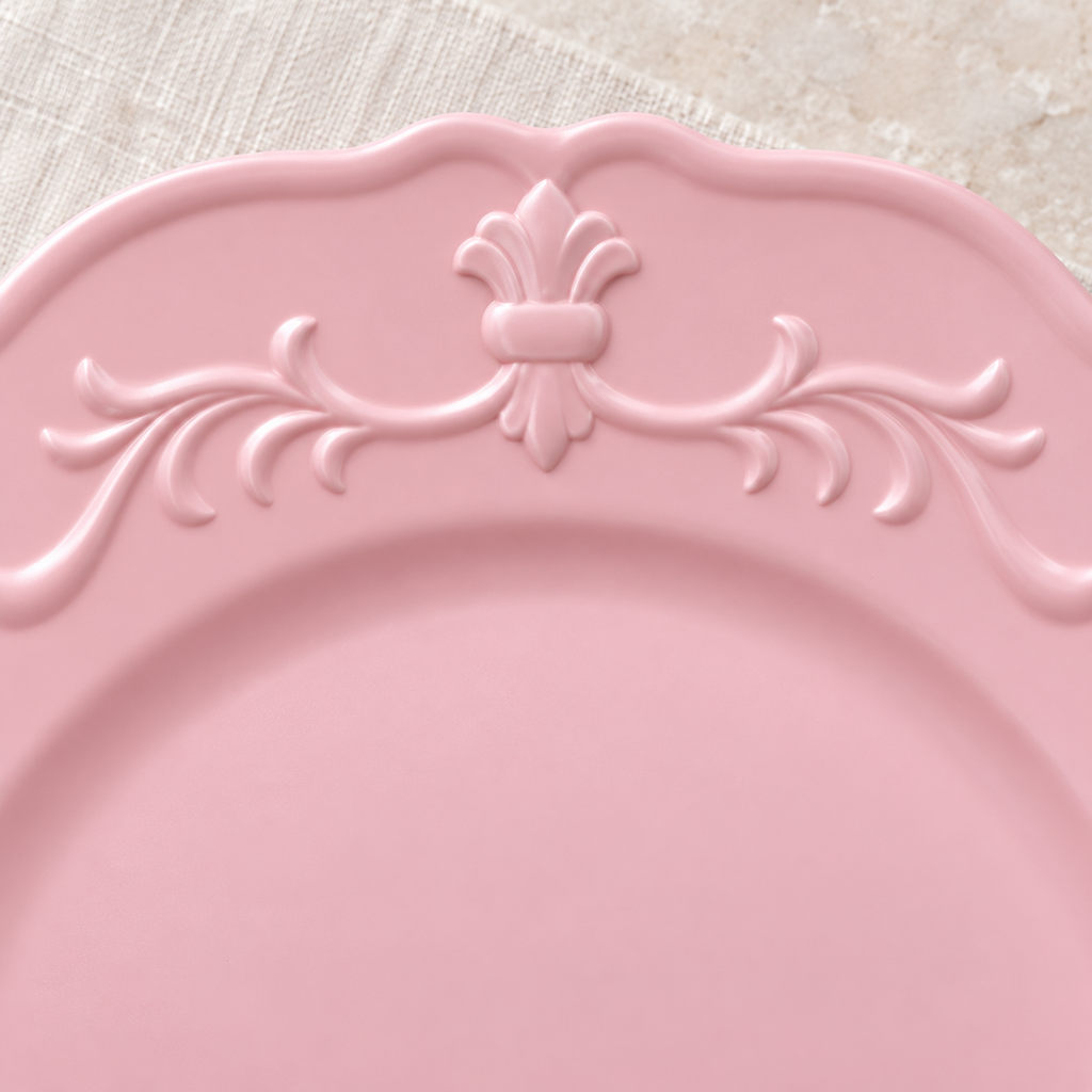 Close detail of the pink charger’s embossed rim ornament.