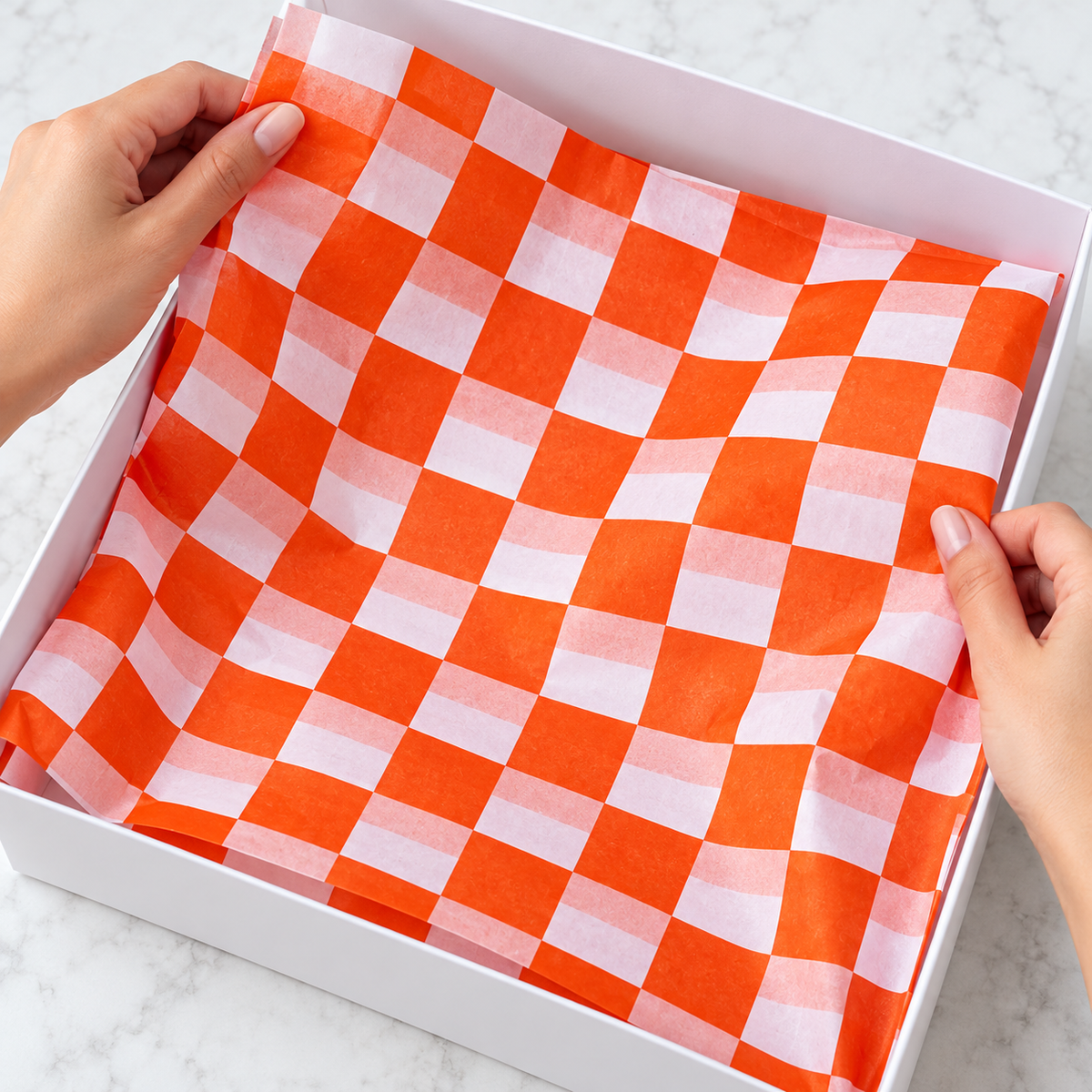 Vivid orange and white check tissue paper, hand photograph, SKU B0D7VJJBM4. Representative sheets from 100-sheet pack; styling not included.
