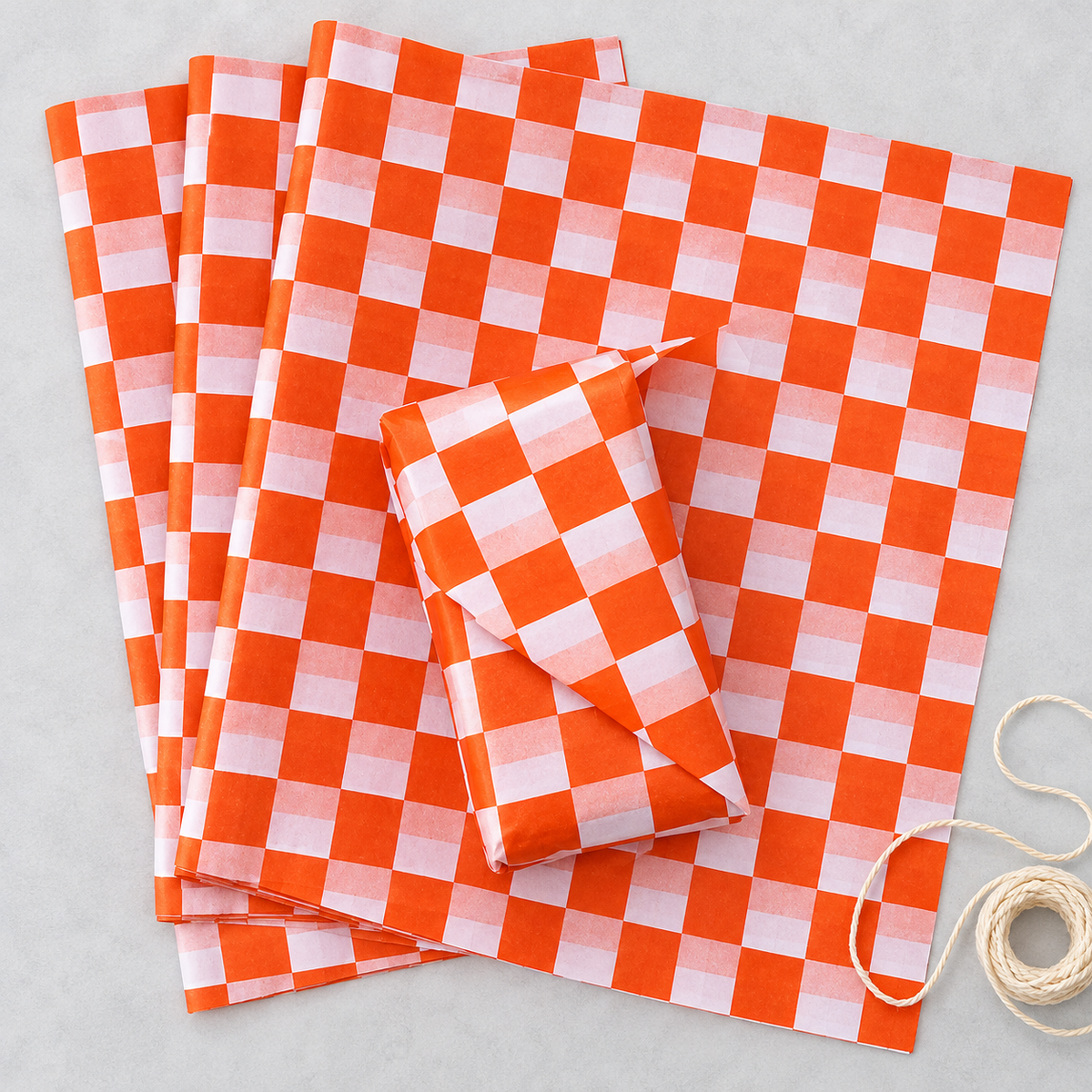 Vivid orange and white check tissue paper, overhead photograph, SKU B0D7VJJBM4. Representative sheets from 100-sheet pack; styling not included.