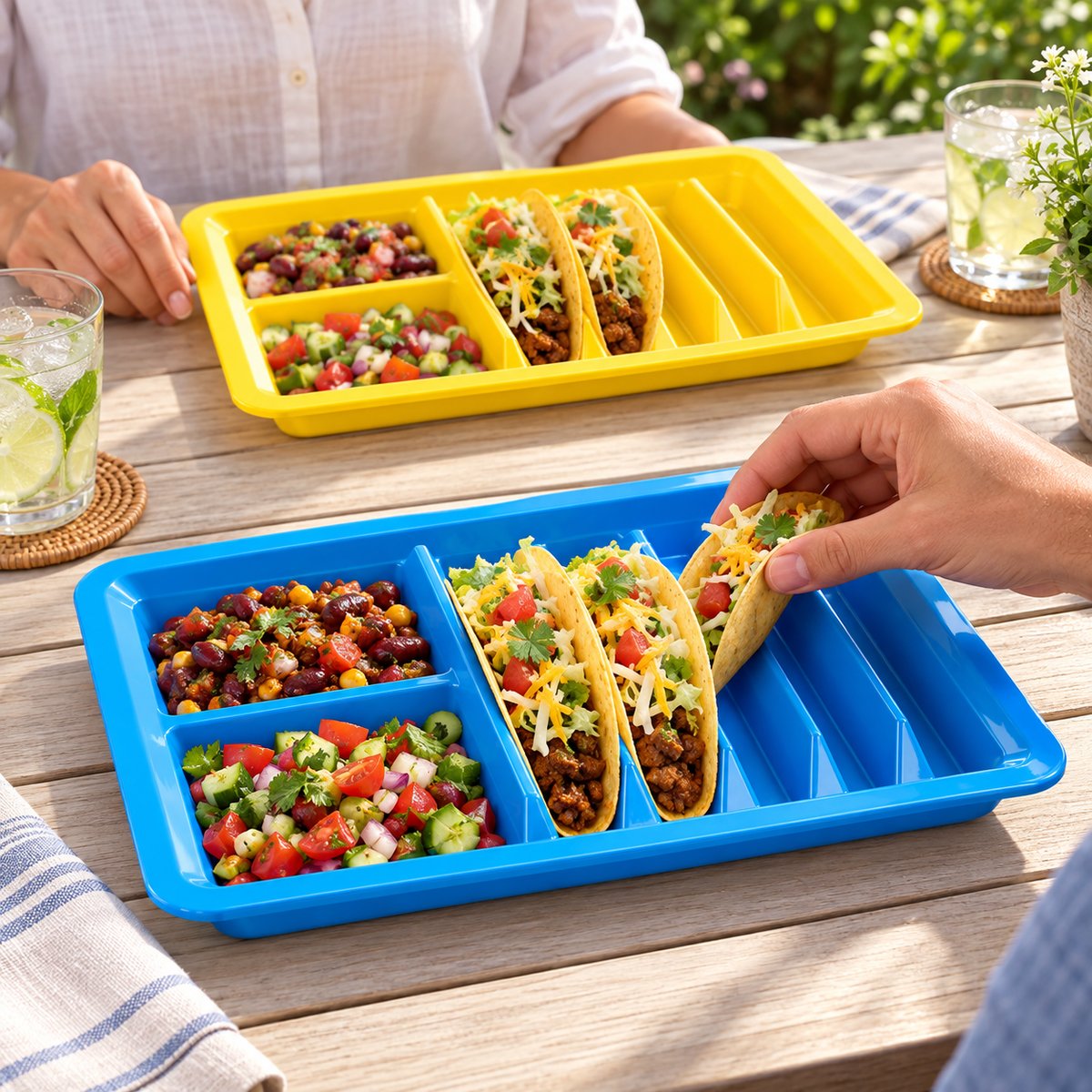 Colorful integral taco trays in a shared meal preparation or dining scene. Representative subset; food and styling props not included.