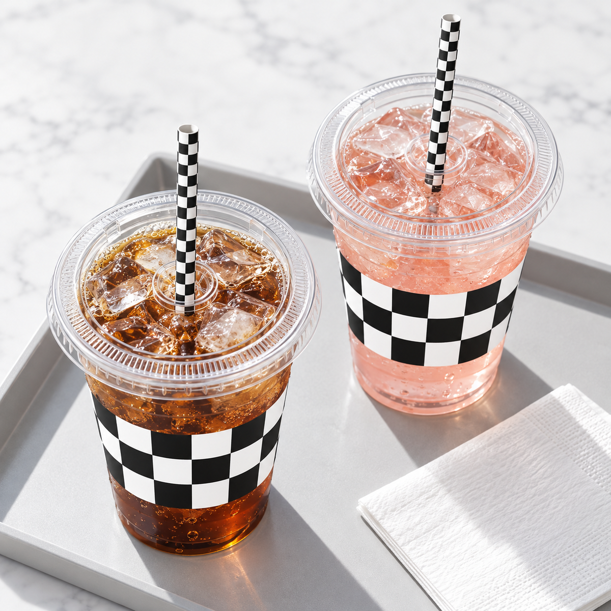 Clear 16 oz checkered party cup with its flat clear lid and checked paper straw, overhead photograph. Representative items from 50 complete sets; drinks and styling props are not included.