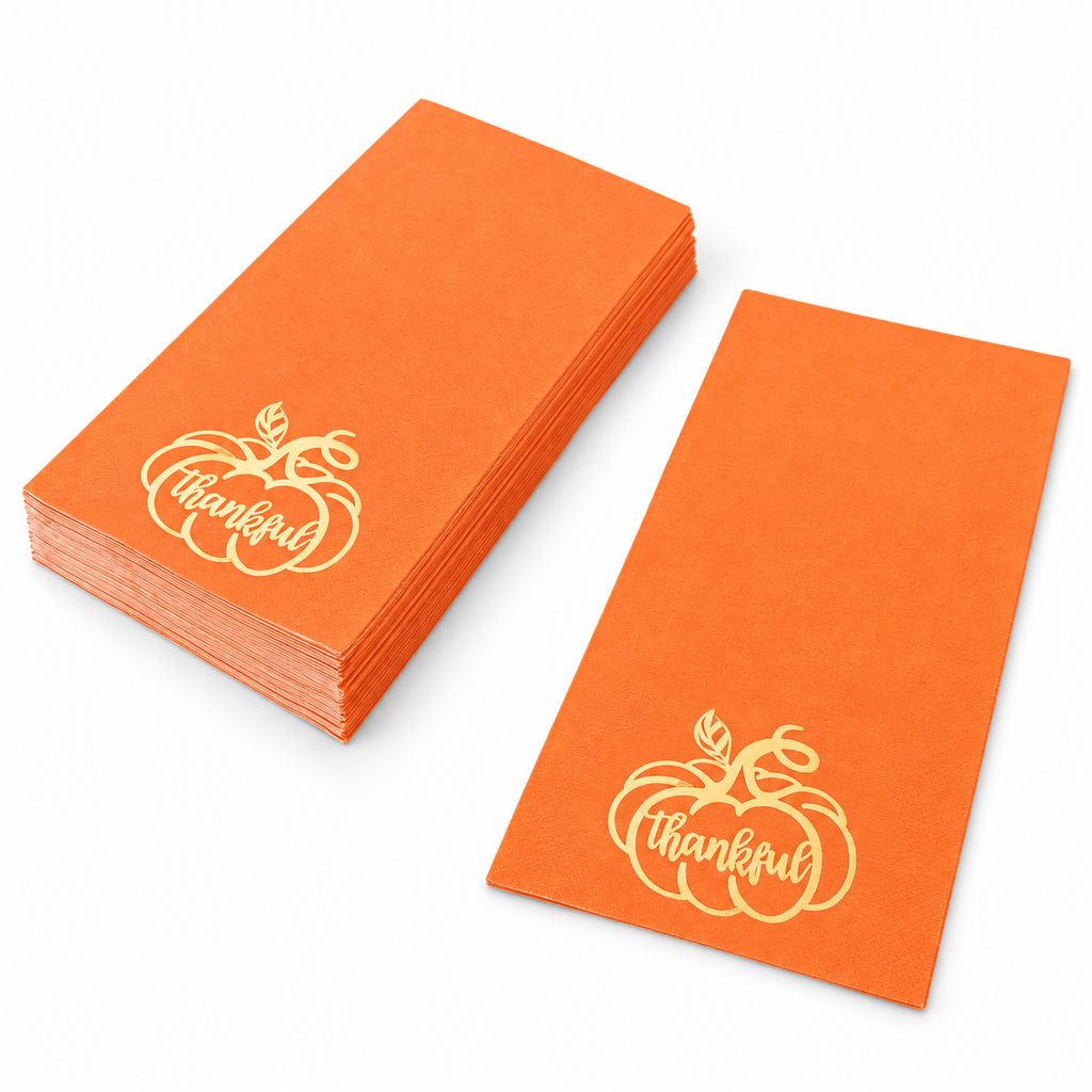 Orange rectangular folded paper napkins with gold pumpkin and Thankful print, shown as a short stack and single napkin on white.