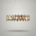 Cascade crystal LED chandelier glowing warm on a soft grey studio backdrop
