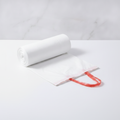 Roll of white drawstring trash bags partly unrolled showing red drawstring — Maison's Kitchen