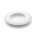 Cratere deep white porcelain soup plate with dimpled textured rim on white