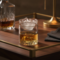 Fuji whiskey glass styled on a dark wood bar cart with decanter and warm lamplight