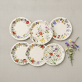 Overhead flat-lay of six wildflower floral paper plate designs fanned on linen