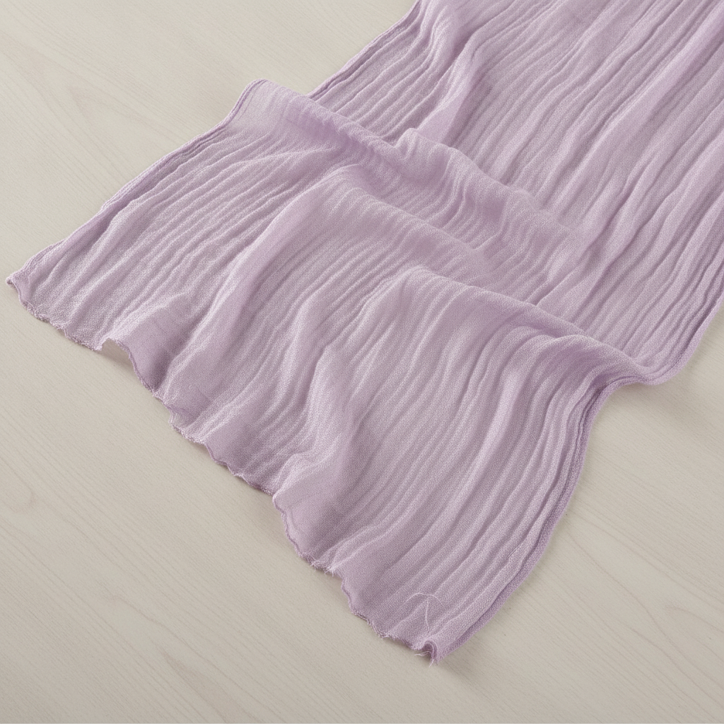 Flat-lay detail of the soft frayed edge of the lavender cheesecloth runner