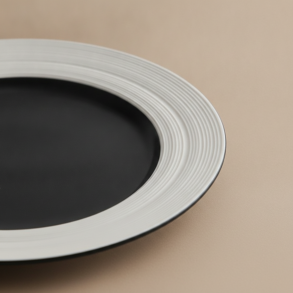 Close-up of ribbed white rim and matte black center on porcelain plate