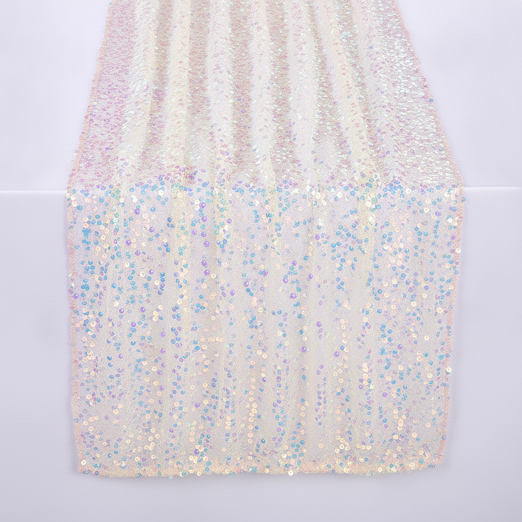 Iridescent champagne sequin table runner draped on a soft-white studio surface, sparkling 5mm sequins catching the light