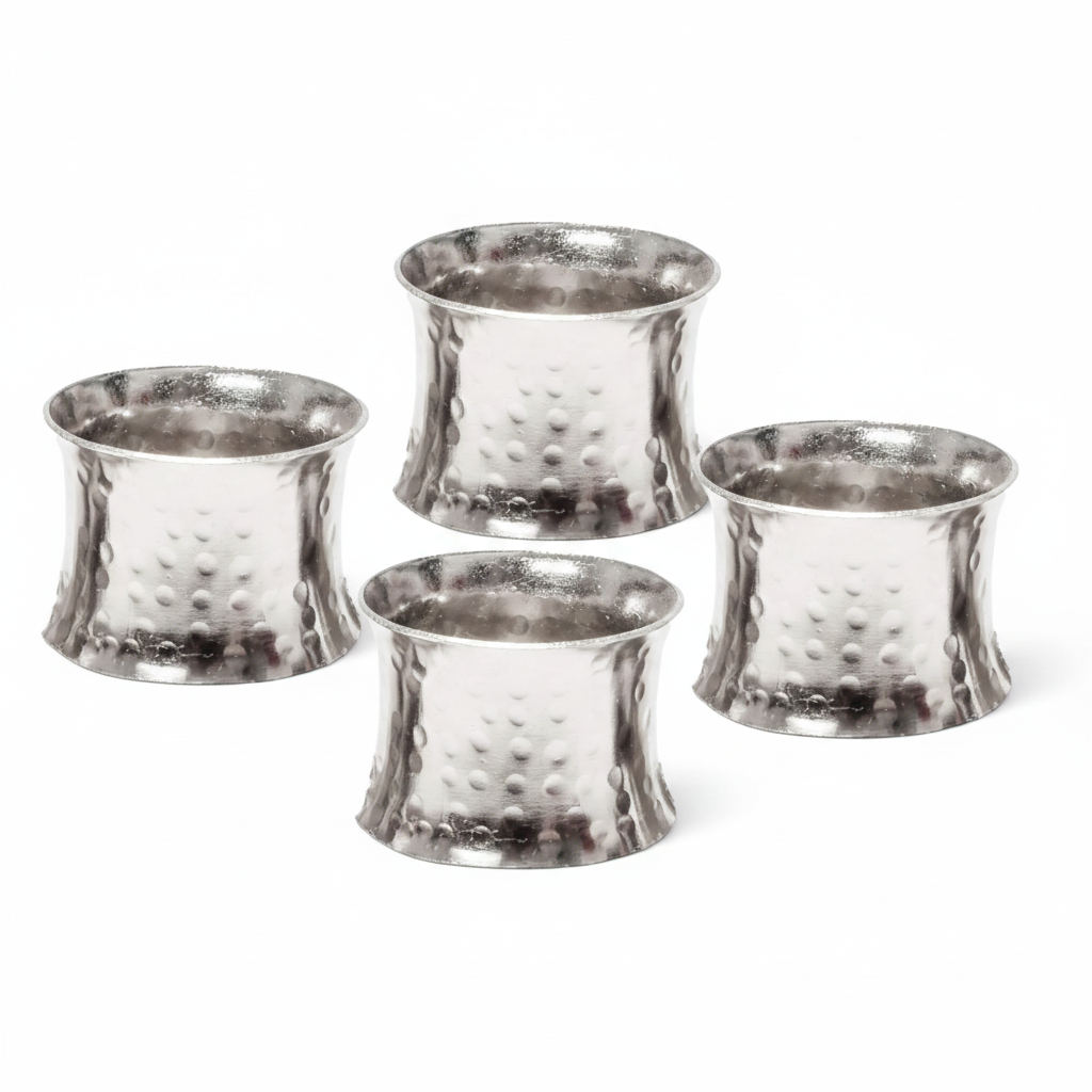 Set of silver beaded napkin rings with hammered metal finish on white background