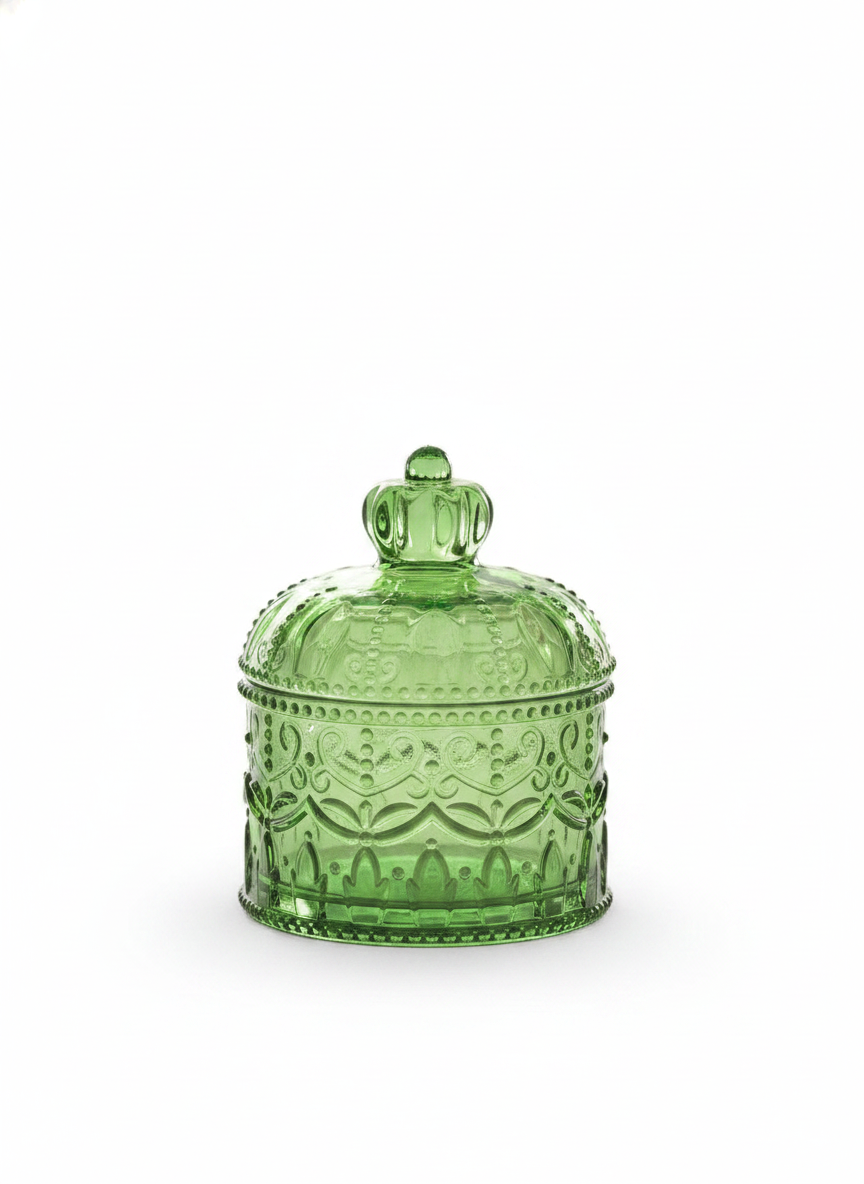 Green crown-lidded embossed glass storage jar on white background