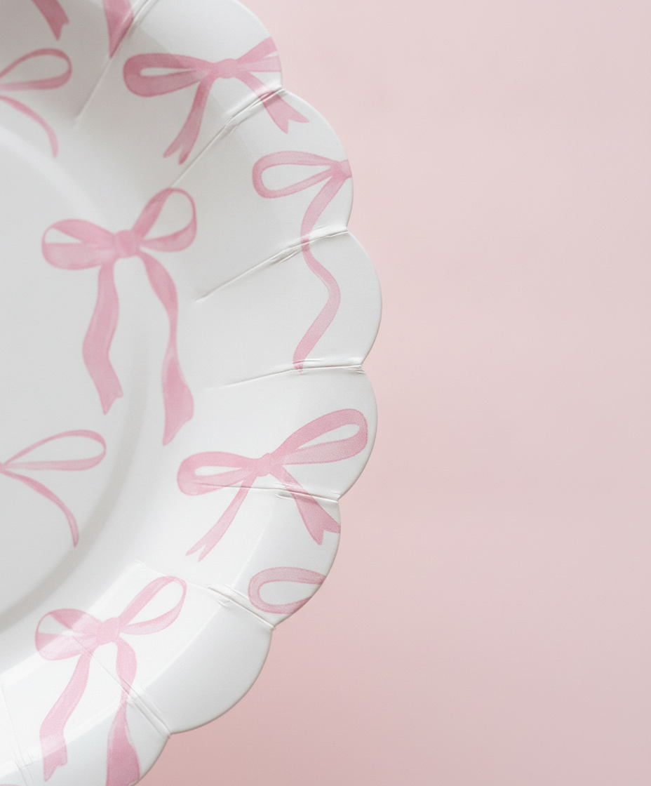 Macro close-up of pink bow scalloped-edge disposable paper party plate
