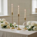 Nozze gold taper candlesticks styled with white roses and eucalyptus as a wedding centrepiece