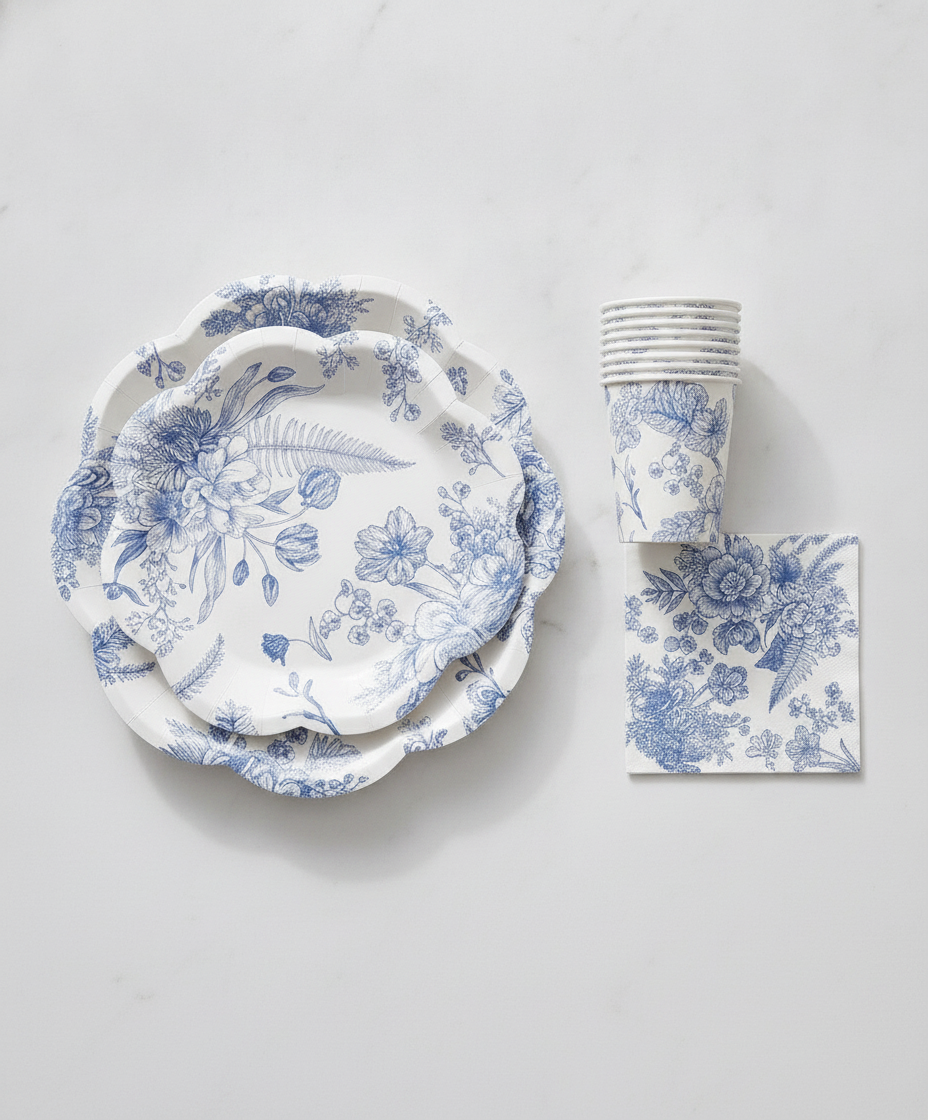 Stacked blue and white floral disposable paper plates with matching cups and napkin