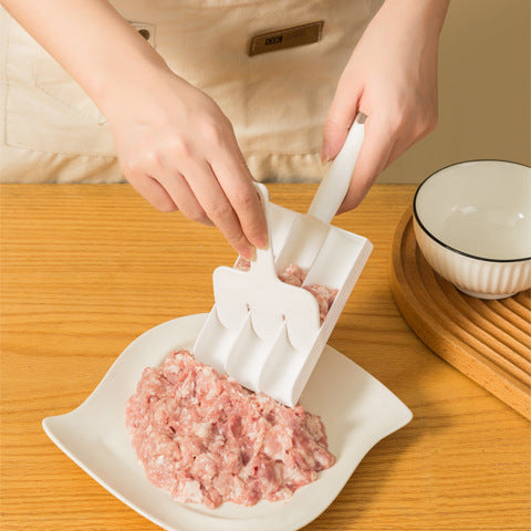 Hands filling the three channels of the meatball scoop from a plate of minced meat