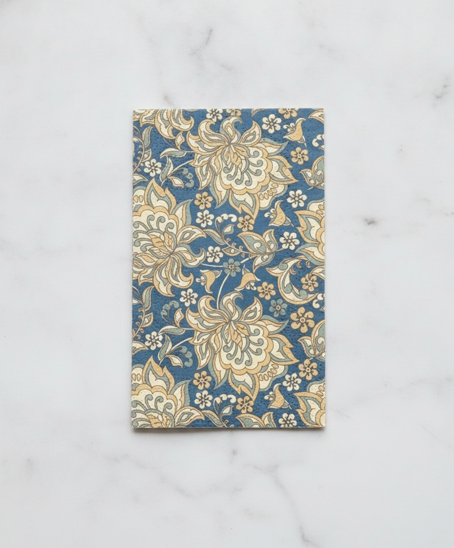 Unfolded rectangular heritage English floral paper guest napkin laid flat showing the full blue and gold pattern