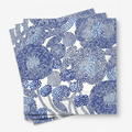 Scandinavian floral paper lunch napkins in cobalt and cream, fanned stack on white
