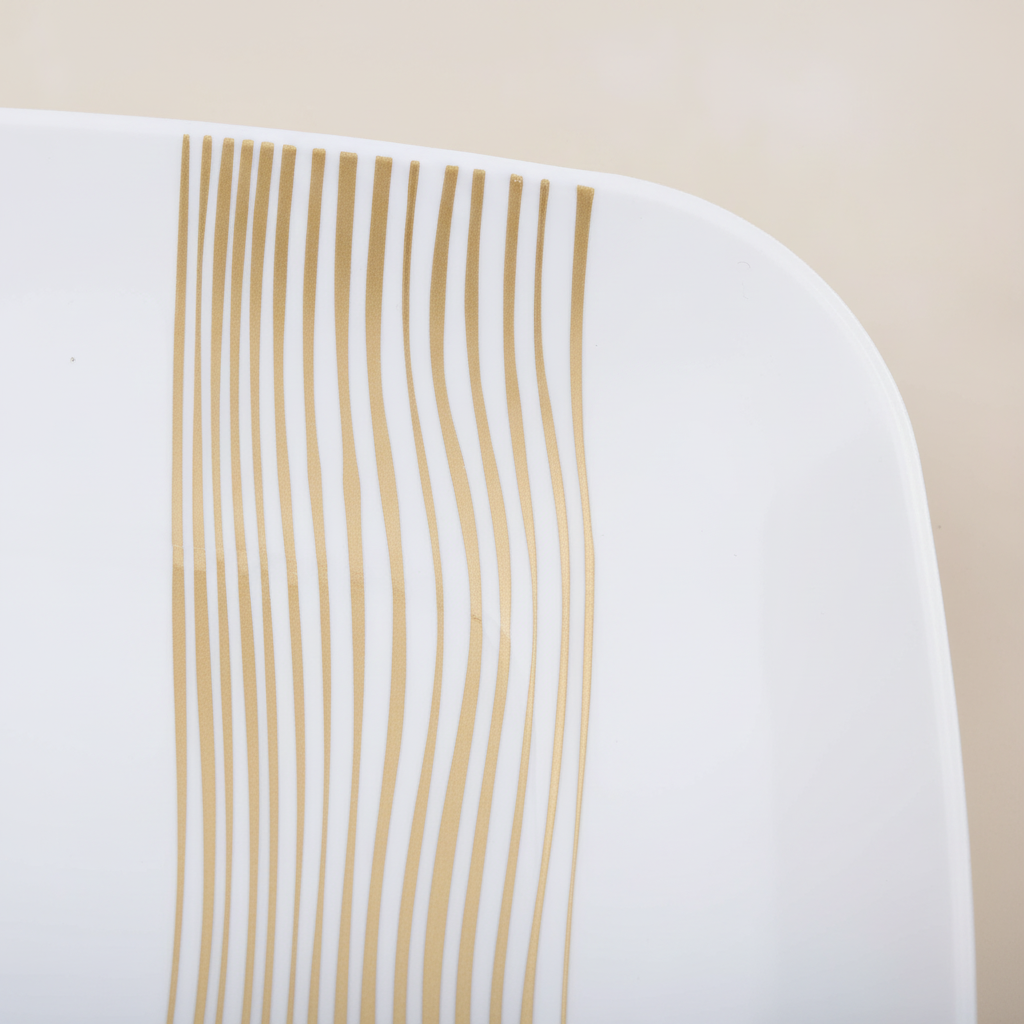Macro detail of the metallic gold wavelet stripe band on a white square plastic plate
