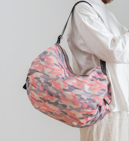 Pink camouflage foldable shopping tote carried over the shoulder