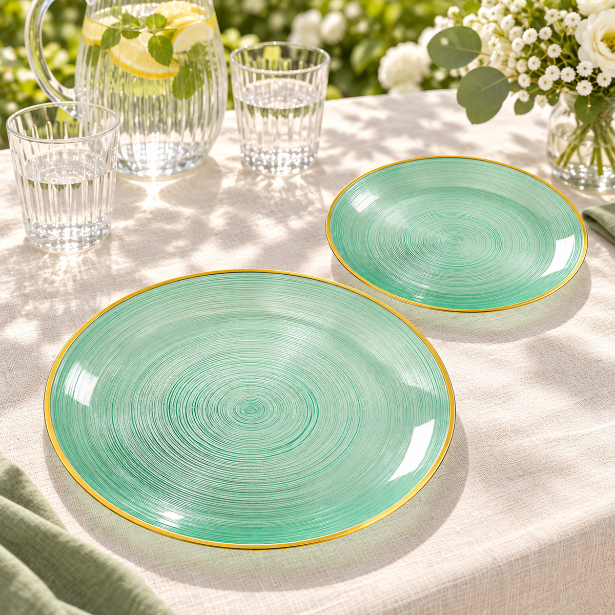 Transparent emerald plates with spiral grooves and a gold rim, garden party tabletop. Food and styling props not included.